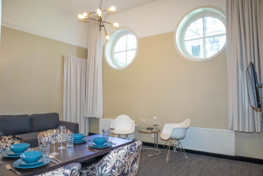 Bright suite with lounge, dining area and tall windows at Golden Mansion Amsterdam