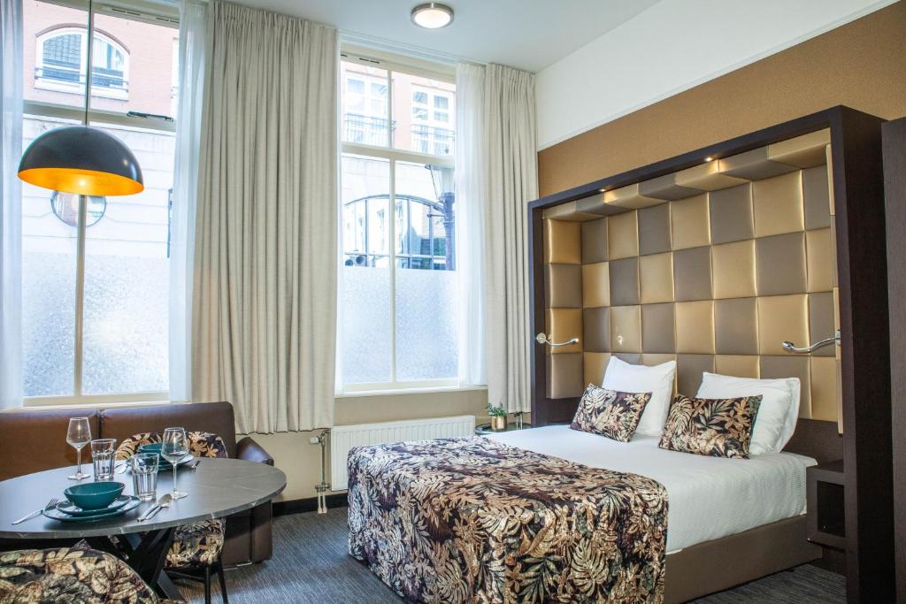 Bright superior studio with seating area and city-facing windows at Golden Mansion Amsterdam